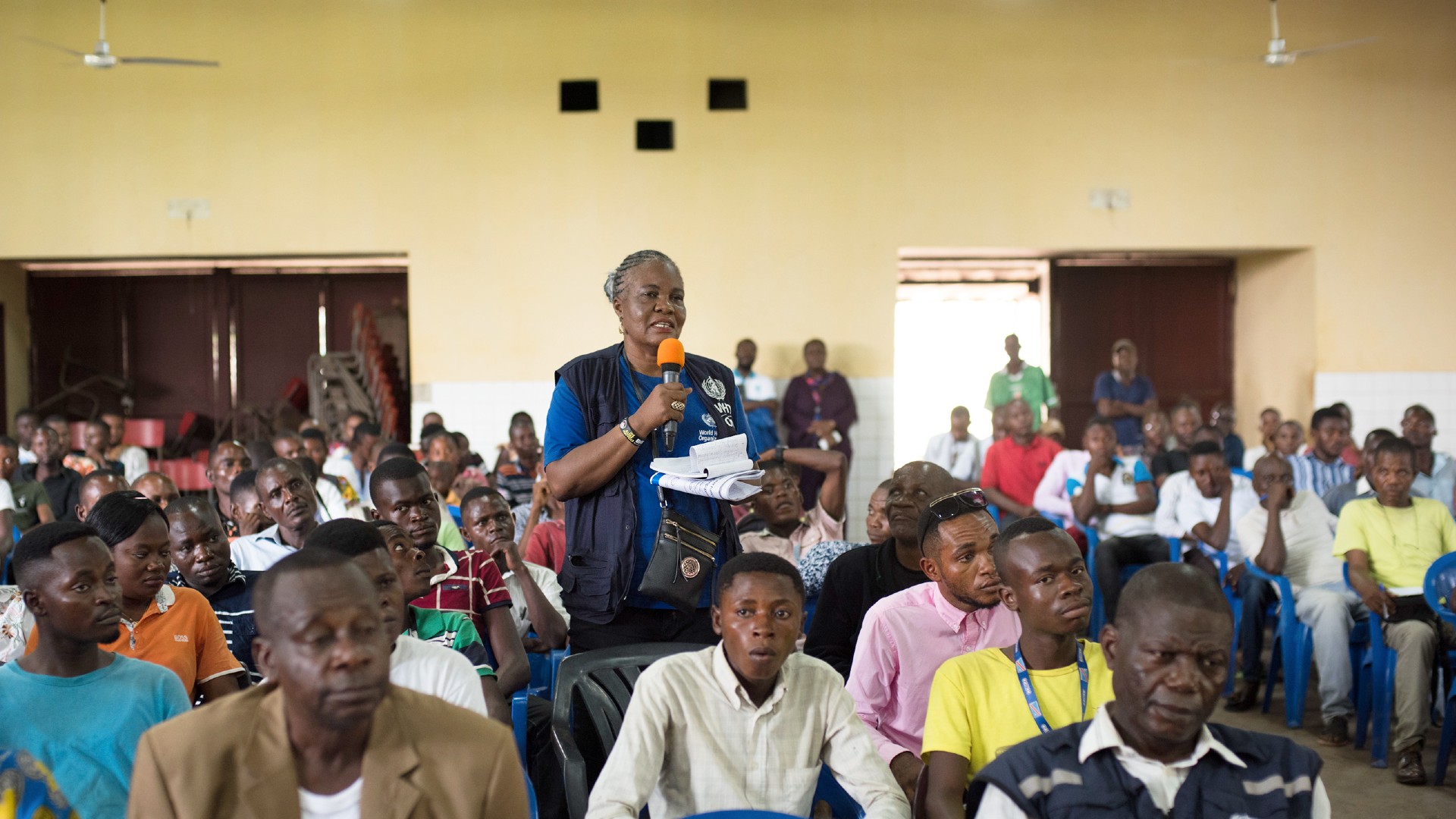 A female social mobilization expert is standing up and talking to a room full of people