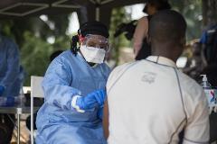 A member of the ring vaccination team vaccinates a man in Bosolo village.