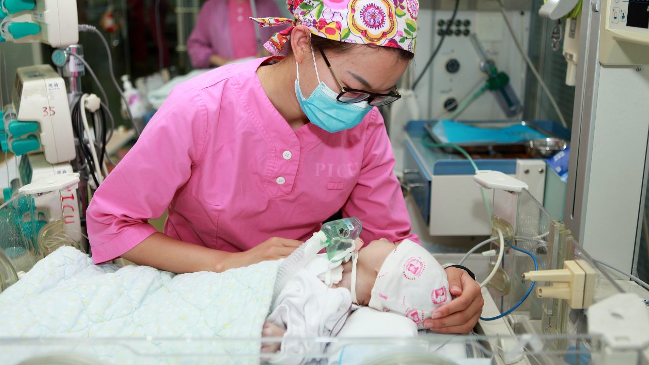 Midwife is checking on a baby.