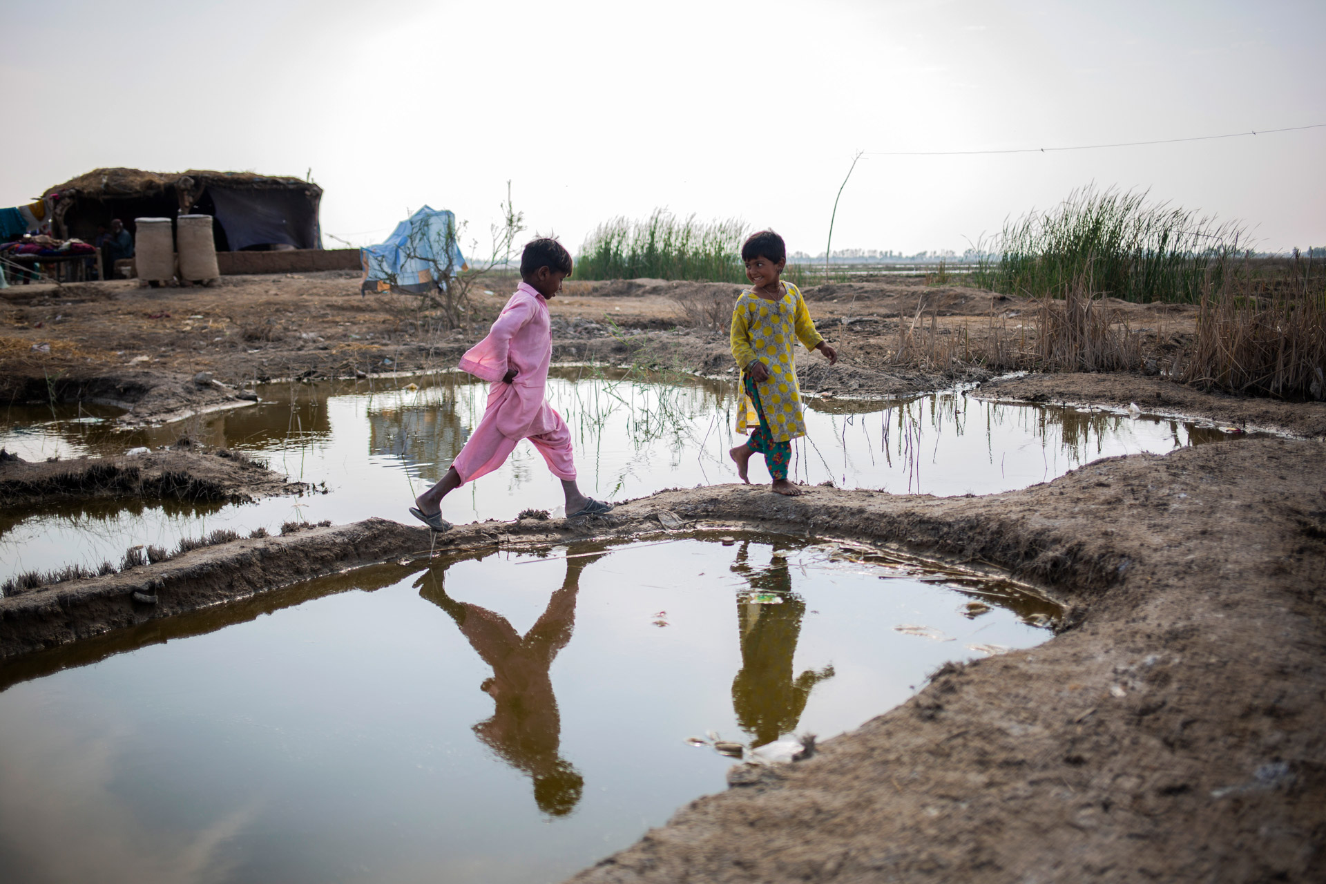Des enfants jouent dans des flaques après des inondations au Pakistan