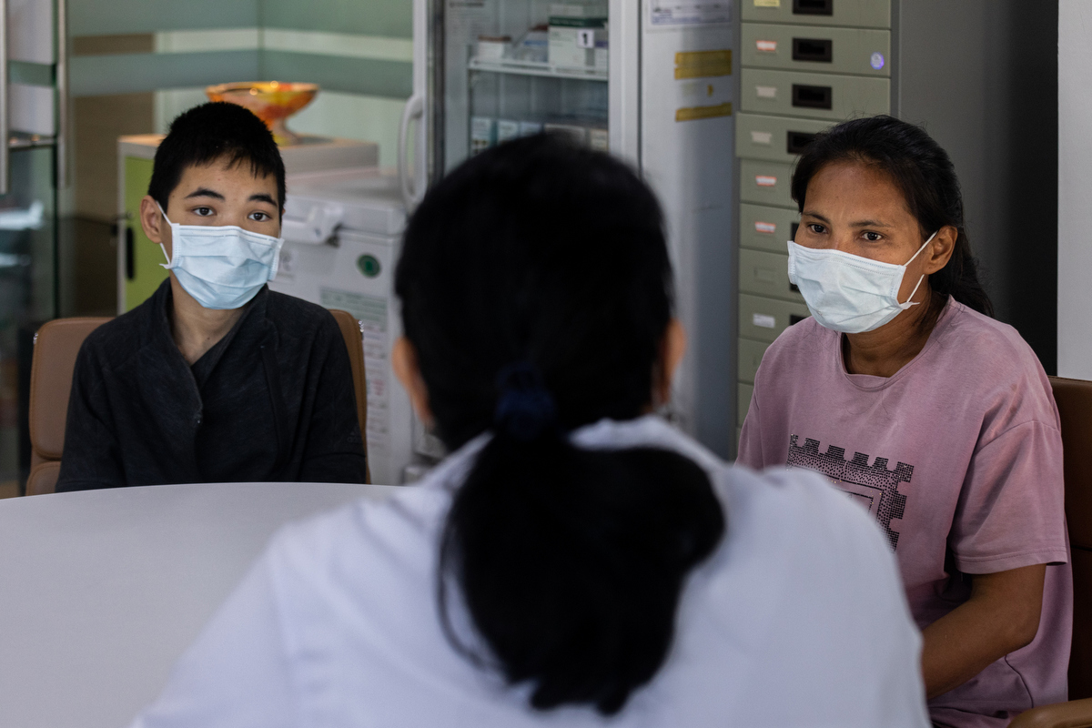 Yingluck Thongtwein, 38, and her son Krittithee, 13, consult with Dr Satariya Trakulsrichai at the Ramathibodi Poison Center. © WHO / Amanda Mustard