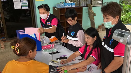 A woman is getting her hypertension checked by a team of health-care providers.
