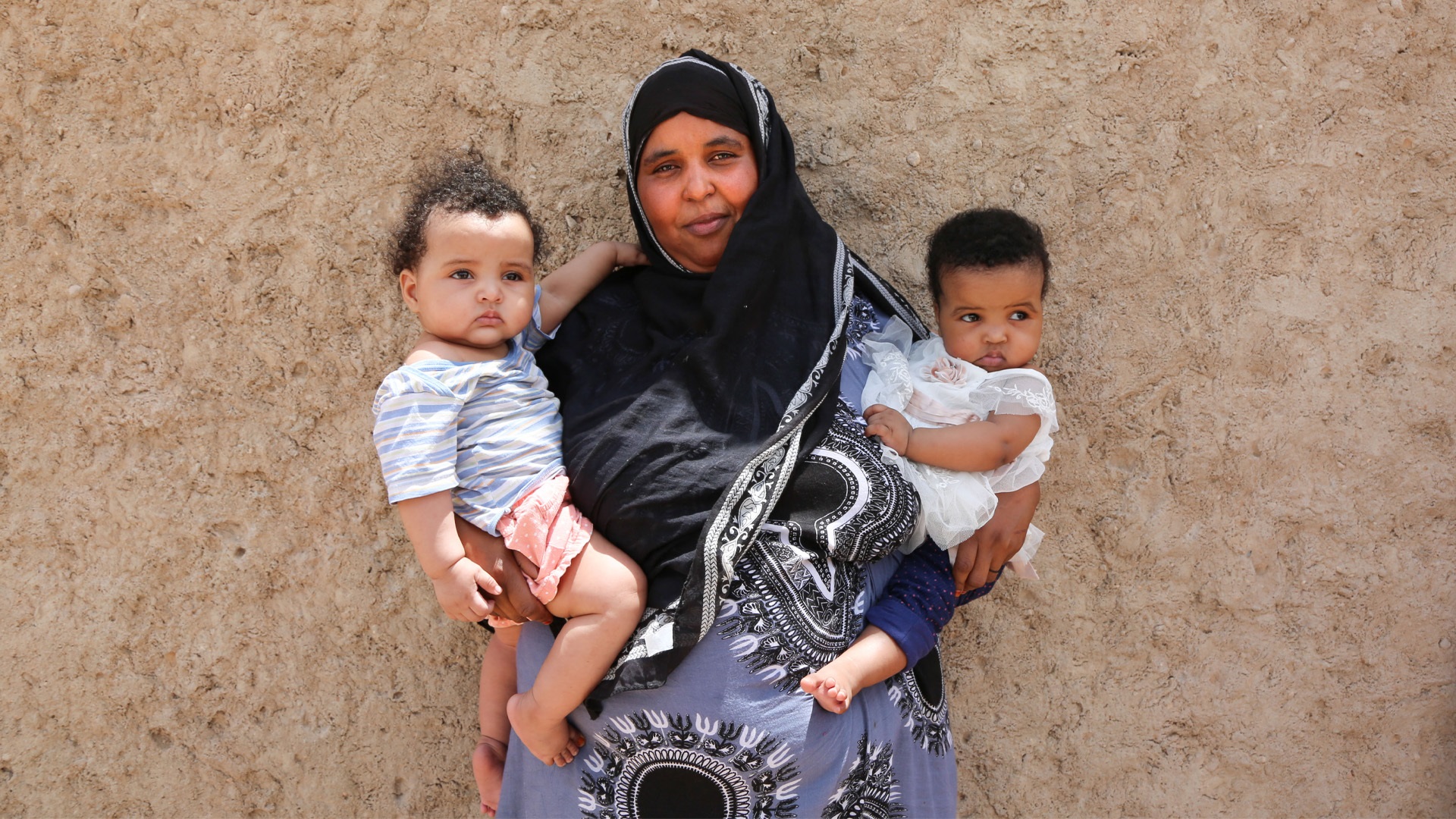 Photo 3 Photo of a mother in Hargeisa holding her 6 month-old twins after they received their polio vaccine.