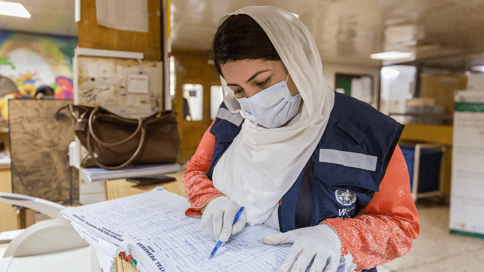 Photo 1 Photo of a doctor checking the register for polio cases at a hospital in Pakistan.