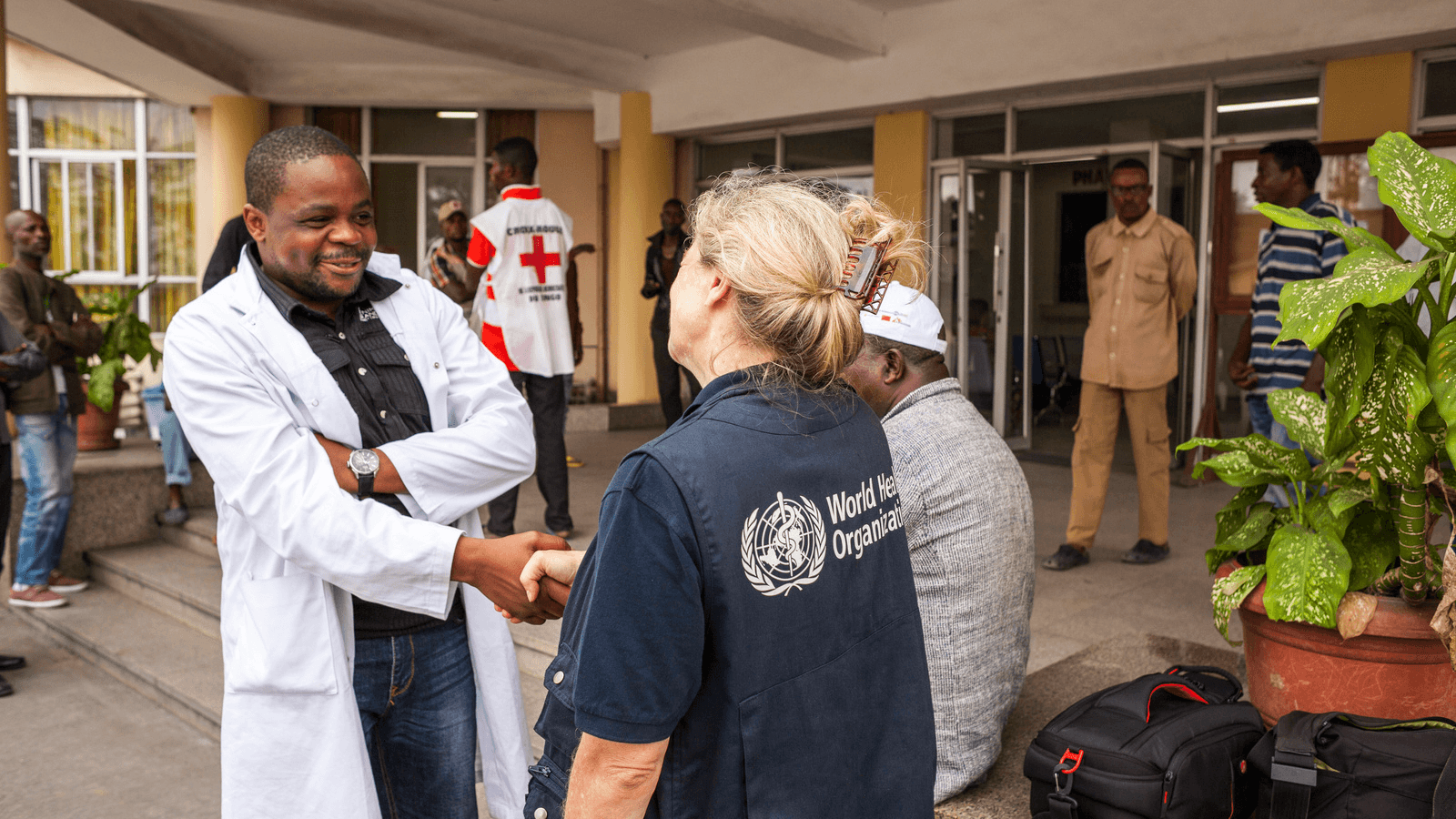 Photo of a WHO agent greeting a doctor at a hospital in Kinshasa, DRC.