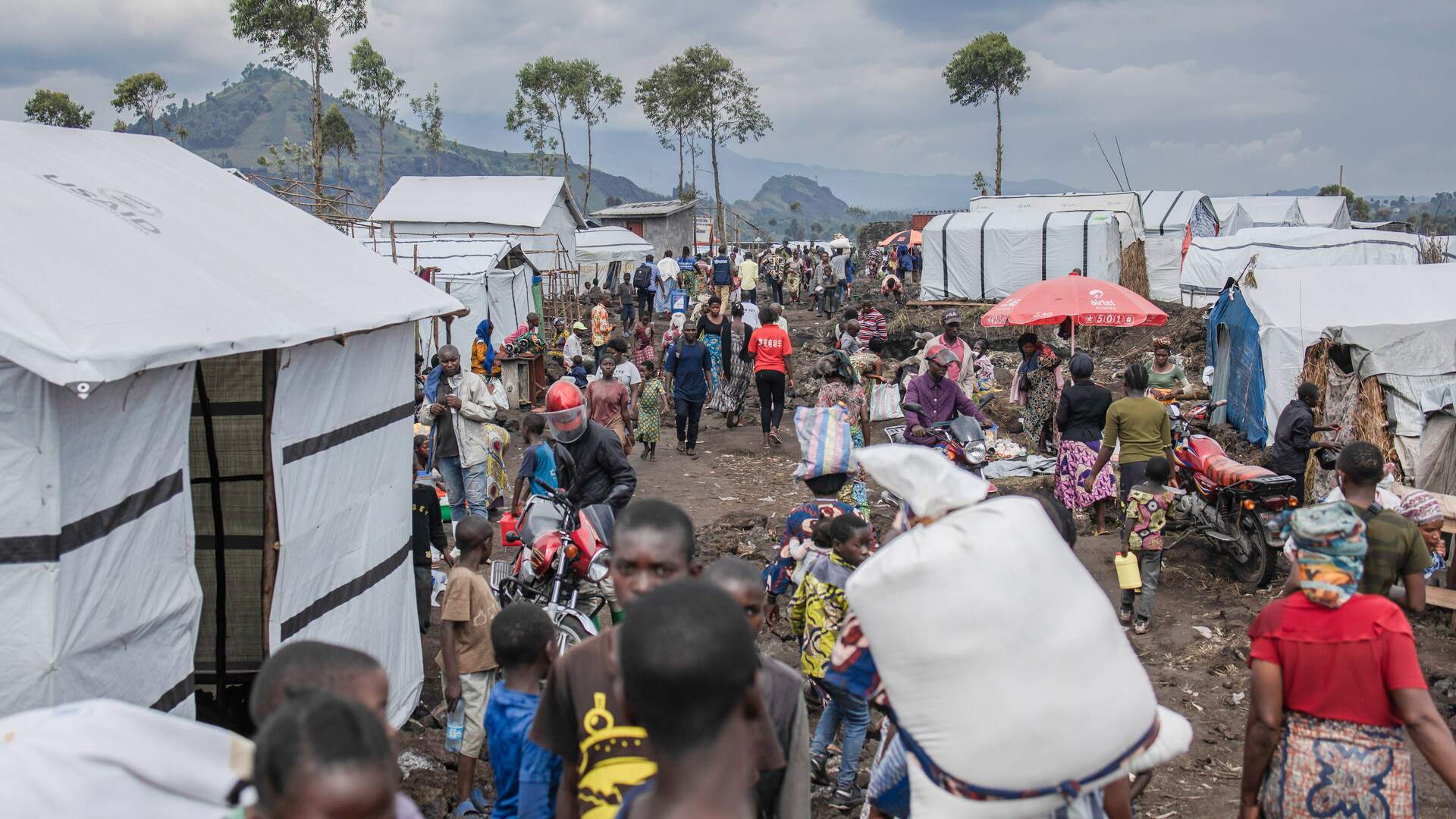 Residents walk through Bulengo camp for internally displaced people