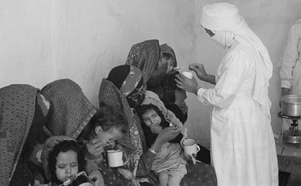 A nurse gives food to a child