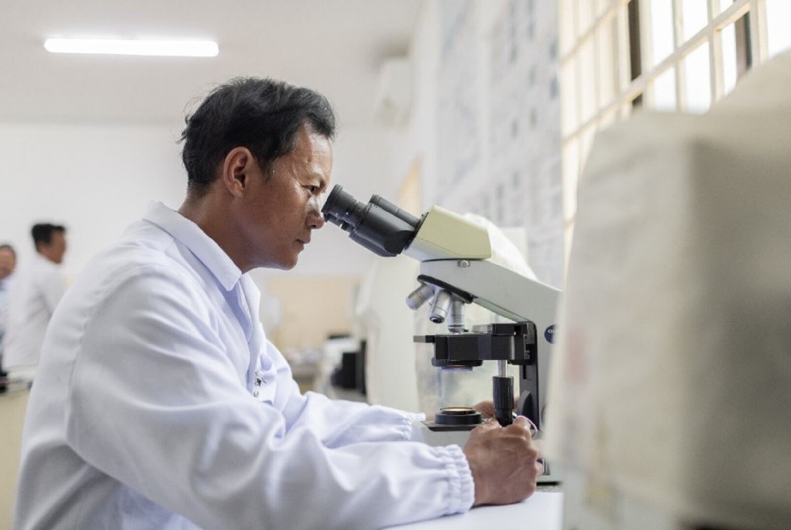 A laboratory techniciam inspects patients' blood samples in a hospital's laboratory room