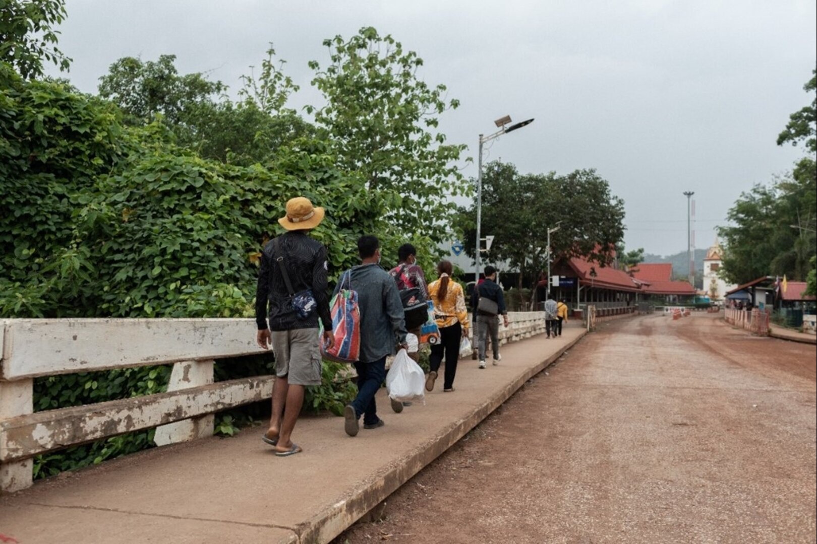 Migrant workers walk from the Cambodia border to Thailand at the Phnom Dey International border checkpoint