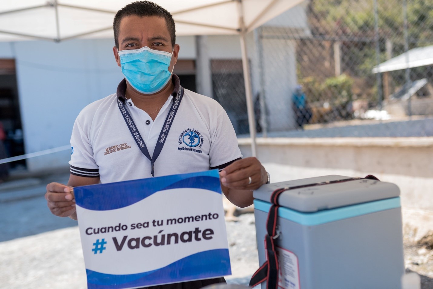 A man wearing a face mask and holding a sign in Spanish saying 