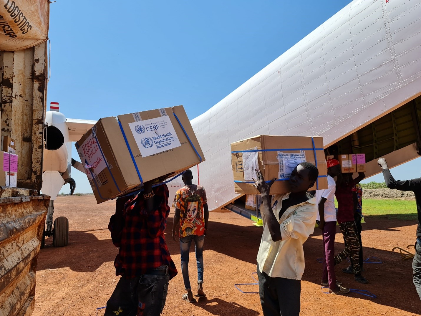 People unloading health kits from an airplane