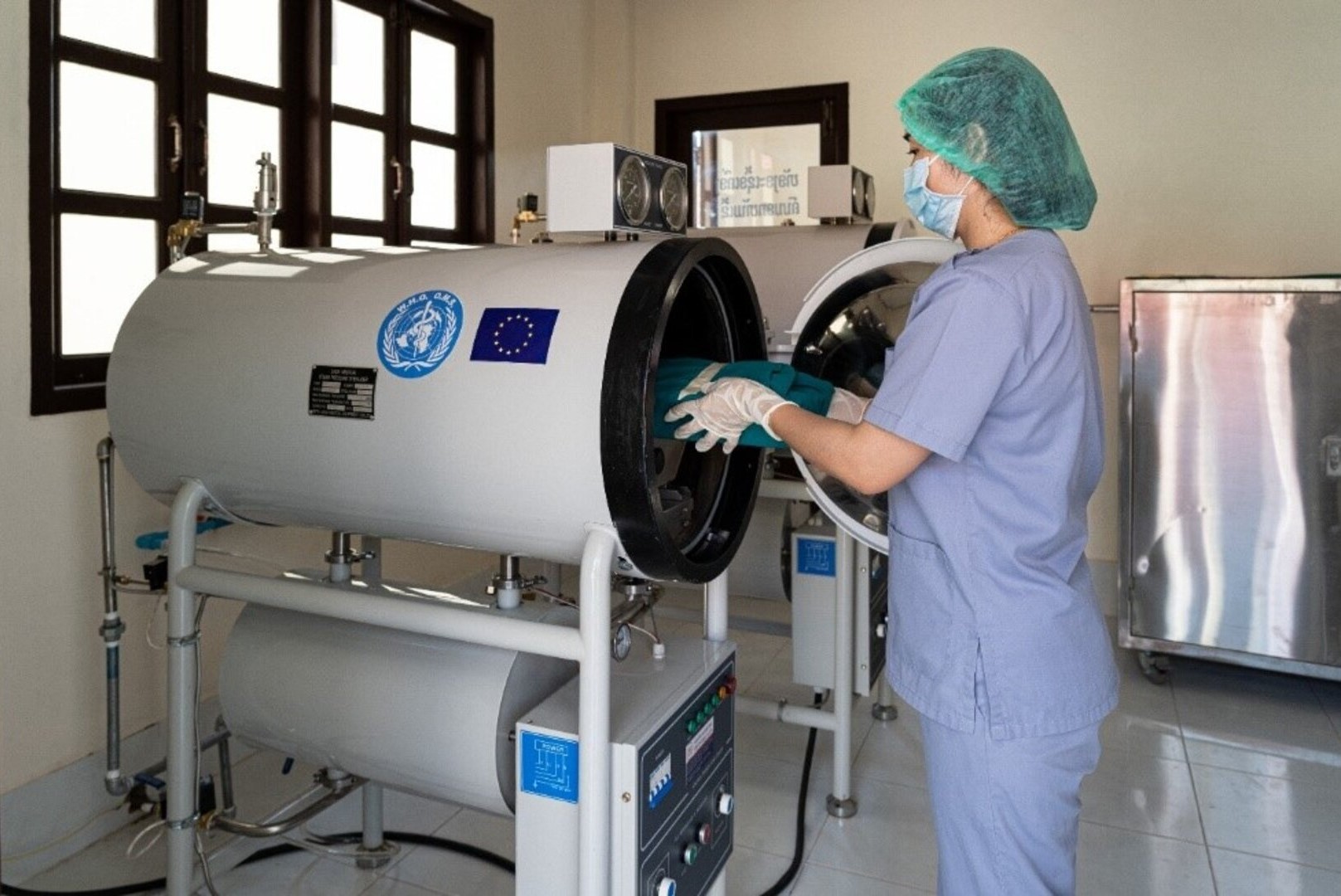 An Infection and Prevetion Control nurse loads medical equipment package into an autoclave machine in the sterilization room