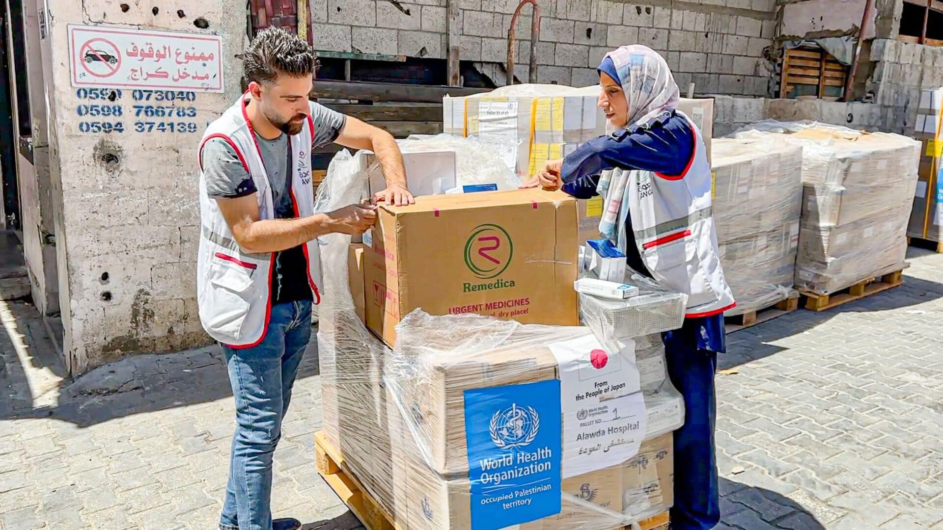 Health workers at Al Awda hospital in Gaza opening medical supplies received from WHO with Japan's support, allowing Gaza hospitals to continue providing lifesaving health care during emergency situations