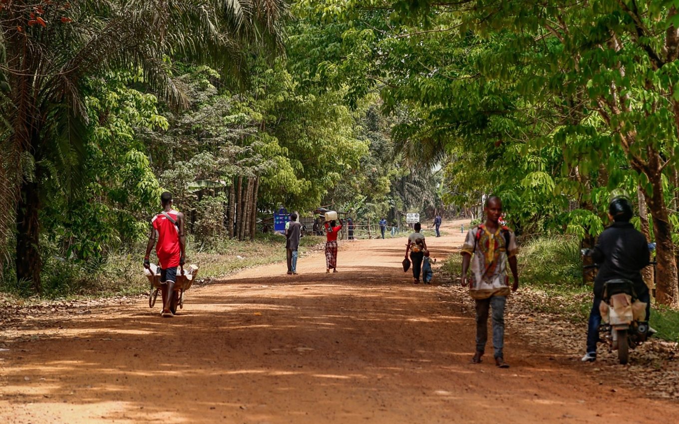 Pedestrians on a dirt road along the Guinea/Liberia border.