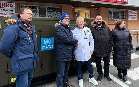WHO staff and recipients posing for a photo after the delivery of a generator in Dipro, Ukraine.