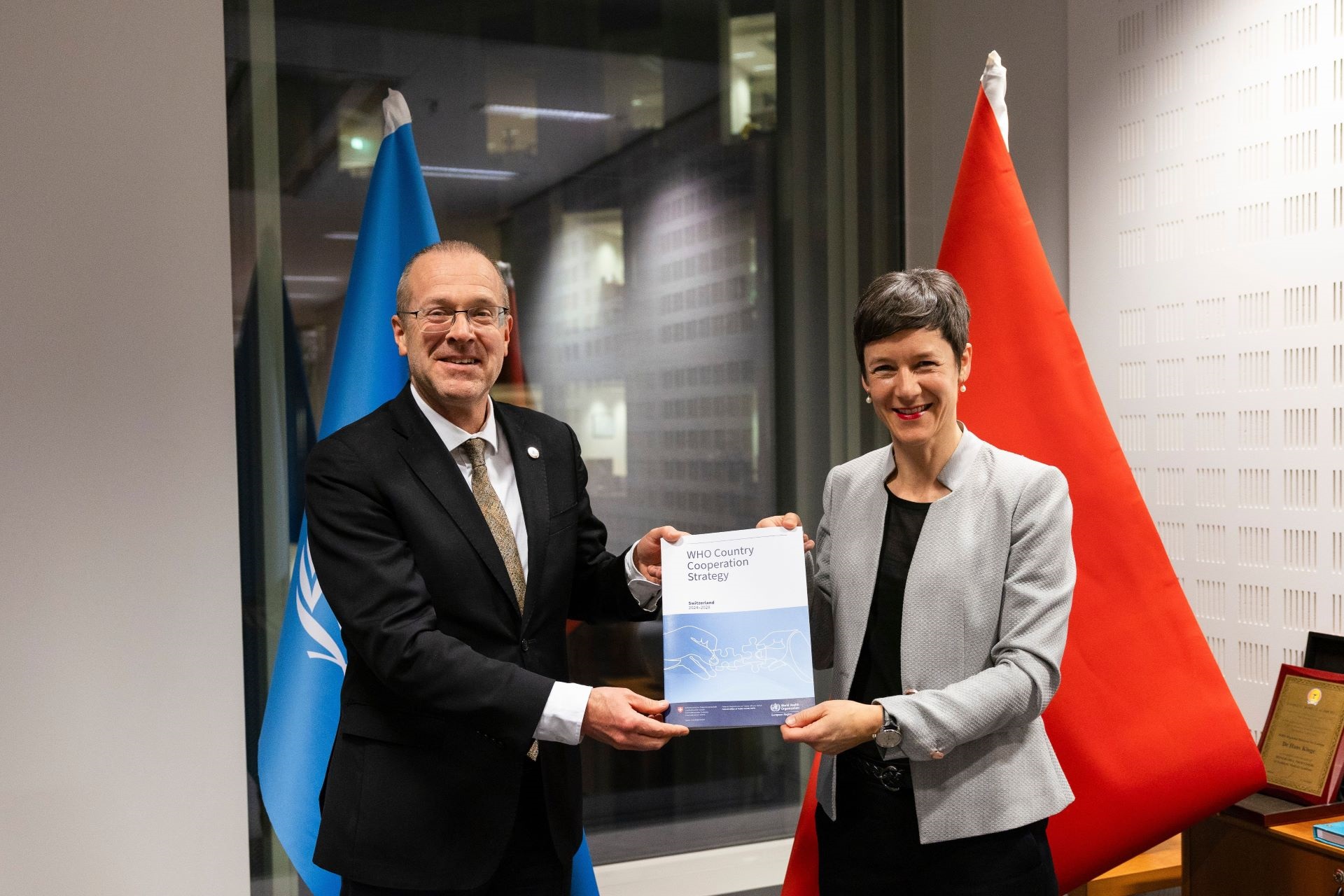 Regional Director of EURO, Dr Hans Kluge holds WHO's Country Cooperation Strategy document with Swiss Ambassador for Global Health, Barbara Schedler