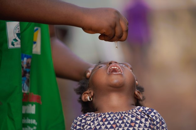 The lifesaving drop of the oral polio vaccine being administered to a child.
