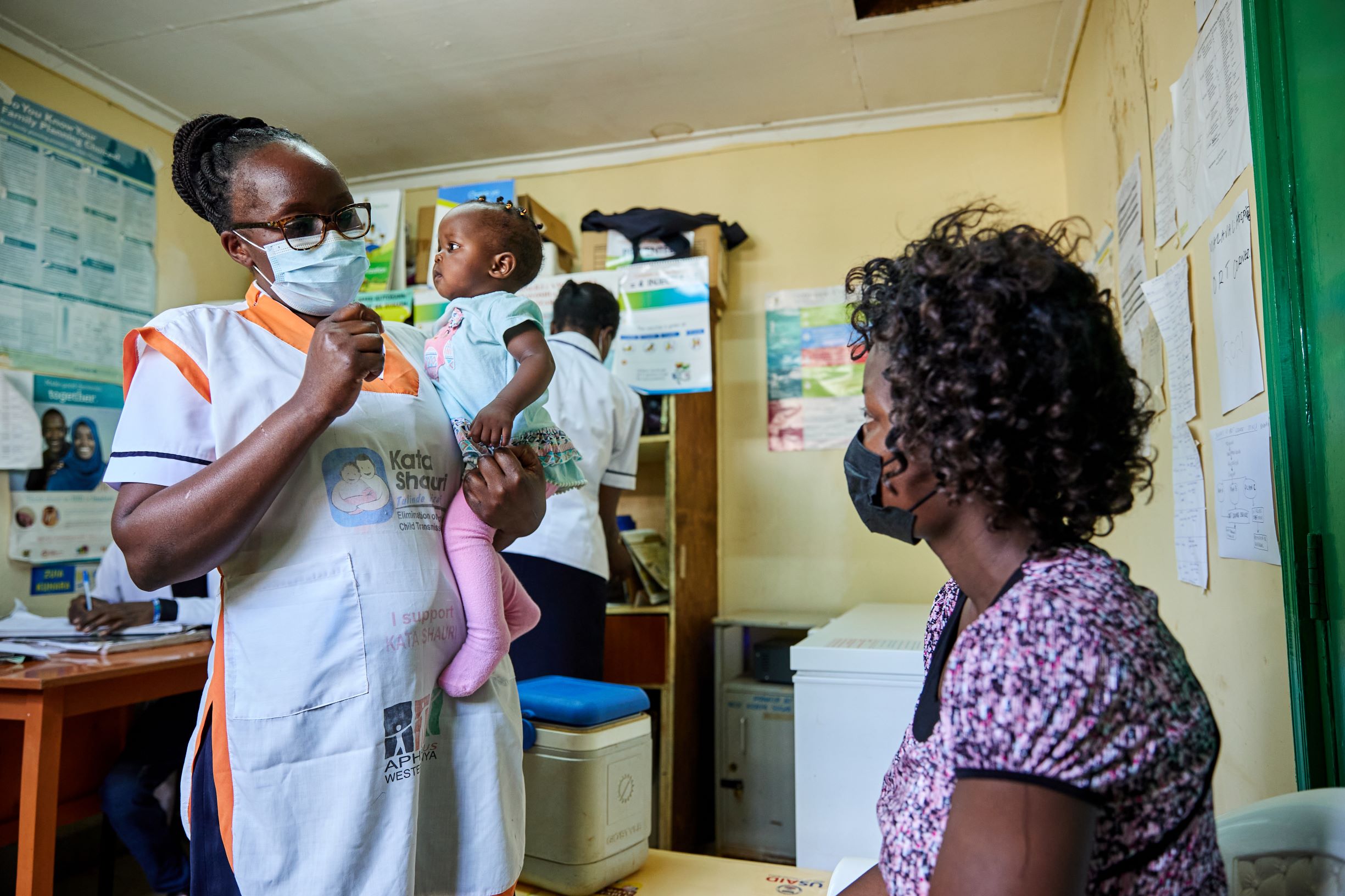 A nurse holds 7-month-old Beverly Wakasa while speaking to her mother at the Malava County Hospital Child Welfare Clinic in Kakamega_Kenya.