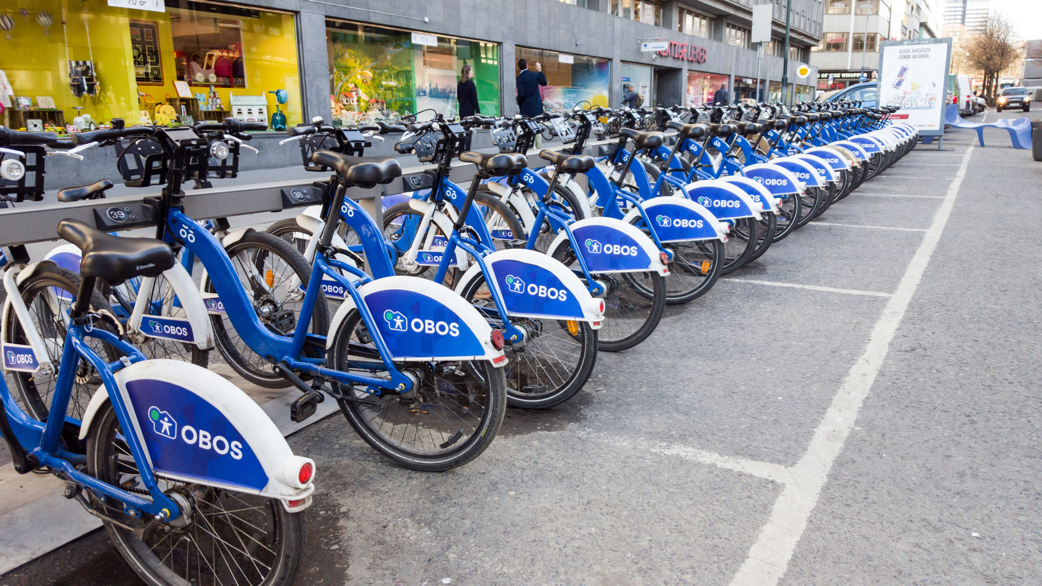 Blue bikes parking at bike public rental station on footpath in town