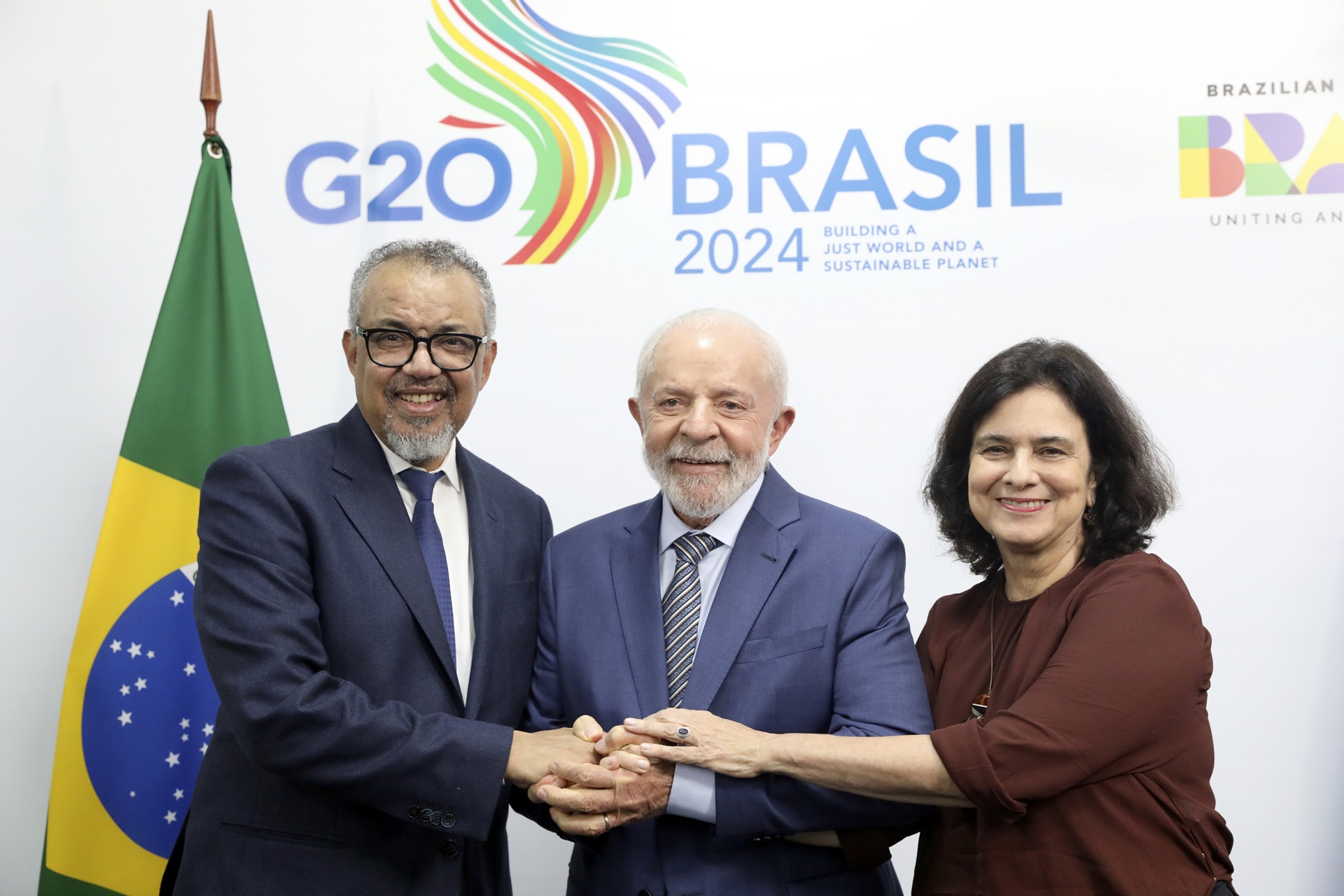 Dr Tedros Adhanom Ghebreyesus, H.E. Luiz Inácio Lula da Silva and Nísia Trindade pose for a photo in front of the backdrop of the G20 Leaders' Summit 2024 in Brazil.