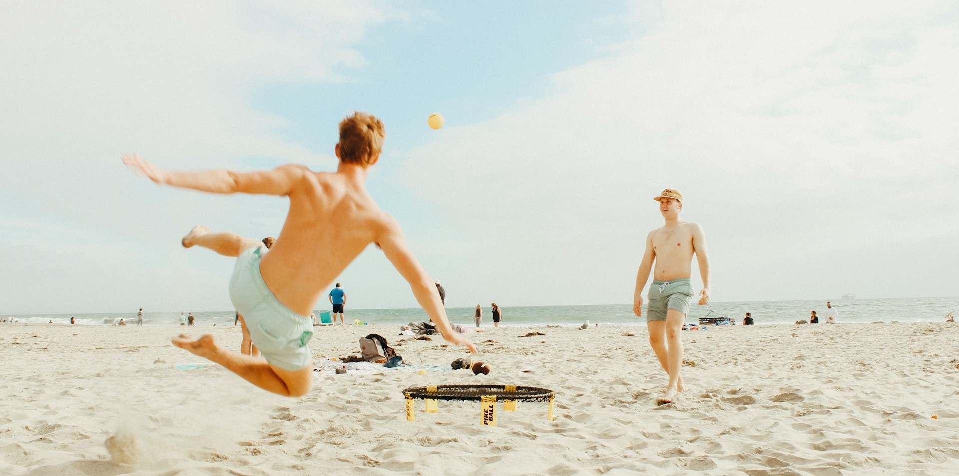 men playing on a beach in the sun