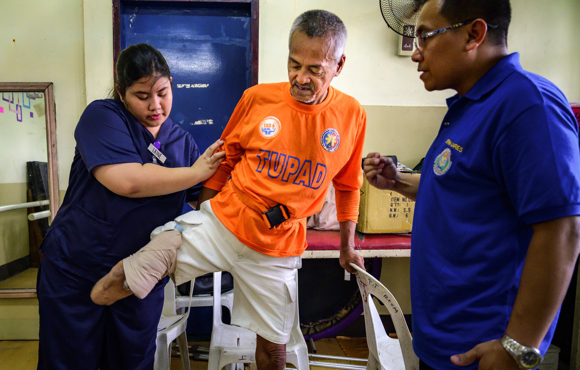Basic package of interventions hero Two health workers assisting a patient.