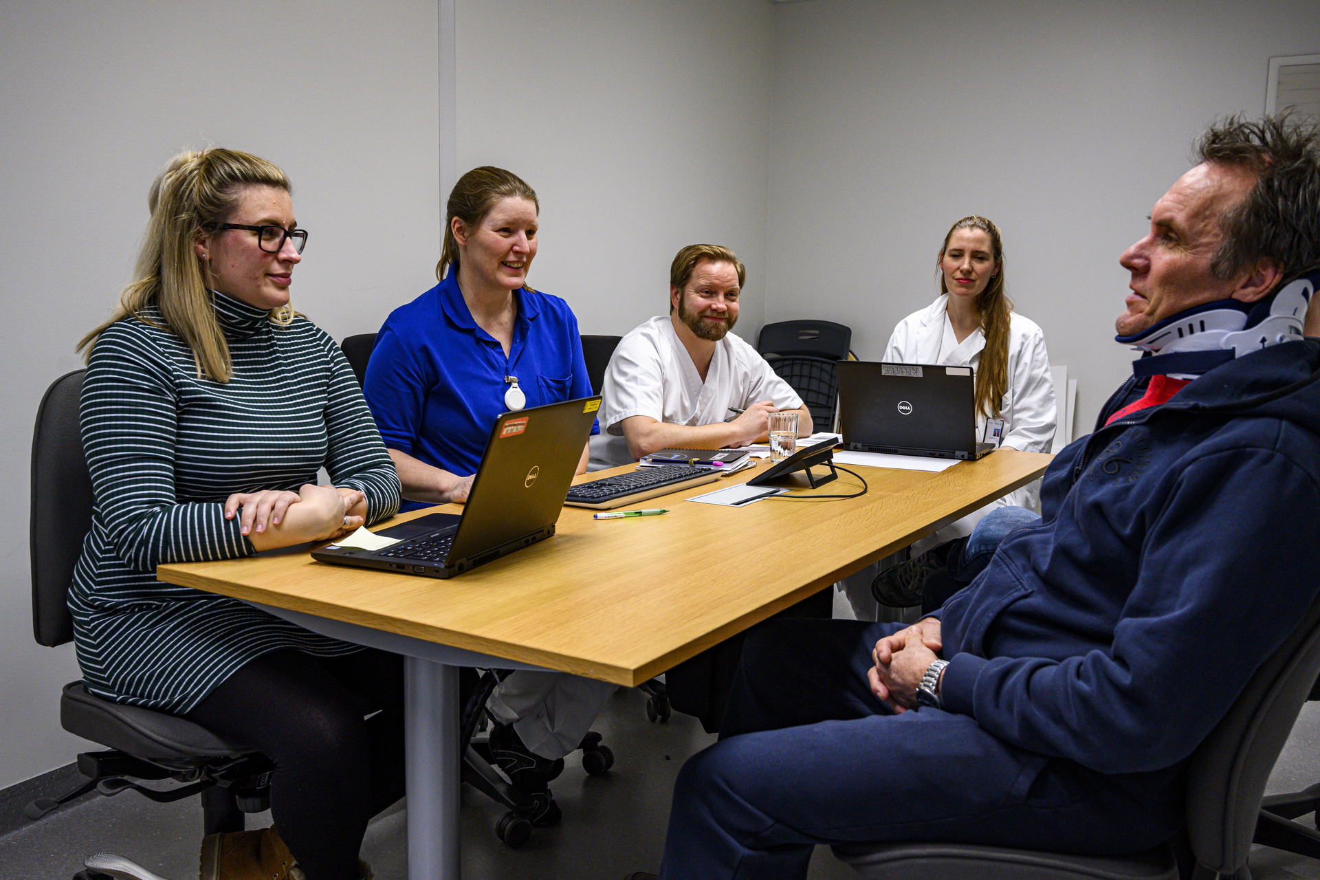 Five people in a multidisciplinary meeting sitting around a table.