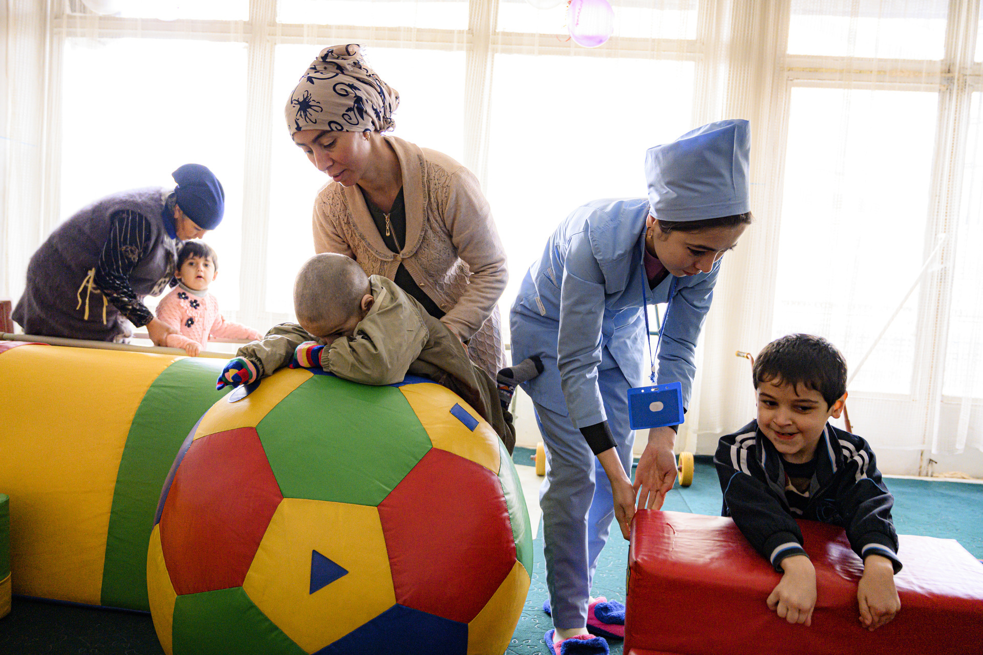 Three children undergoing rehabilitation by three female health workers.
