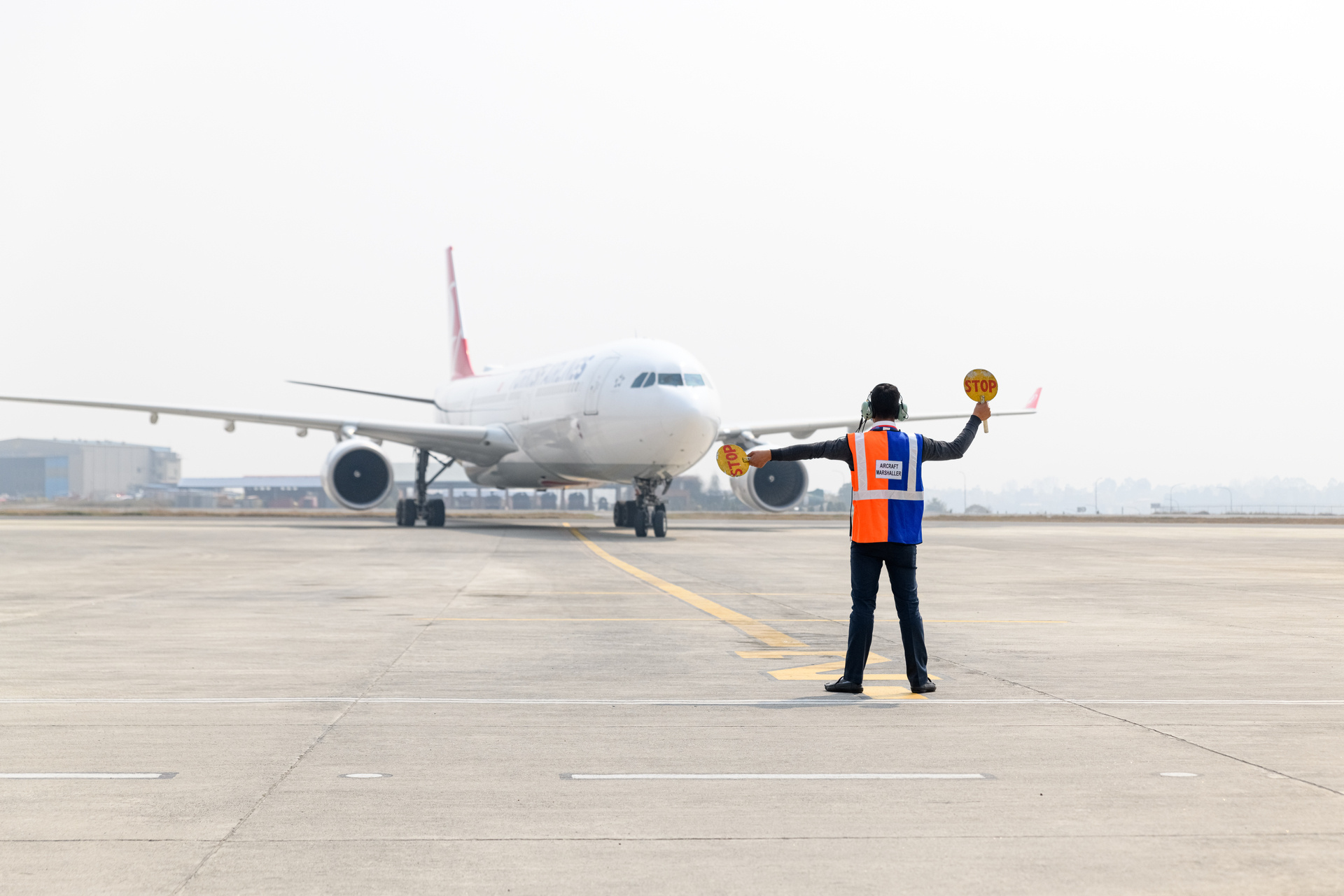 a man with traffic signs in front of a plane