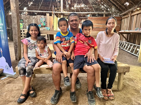 Four children and two adults are sitting on a bench