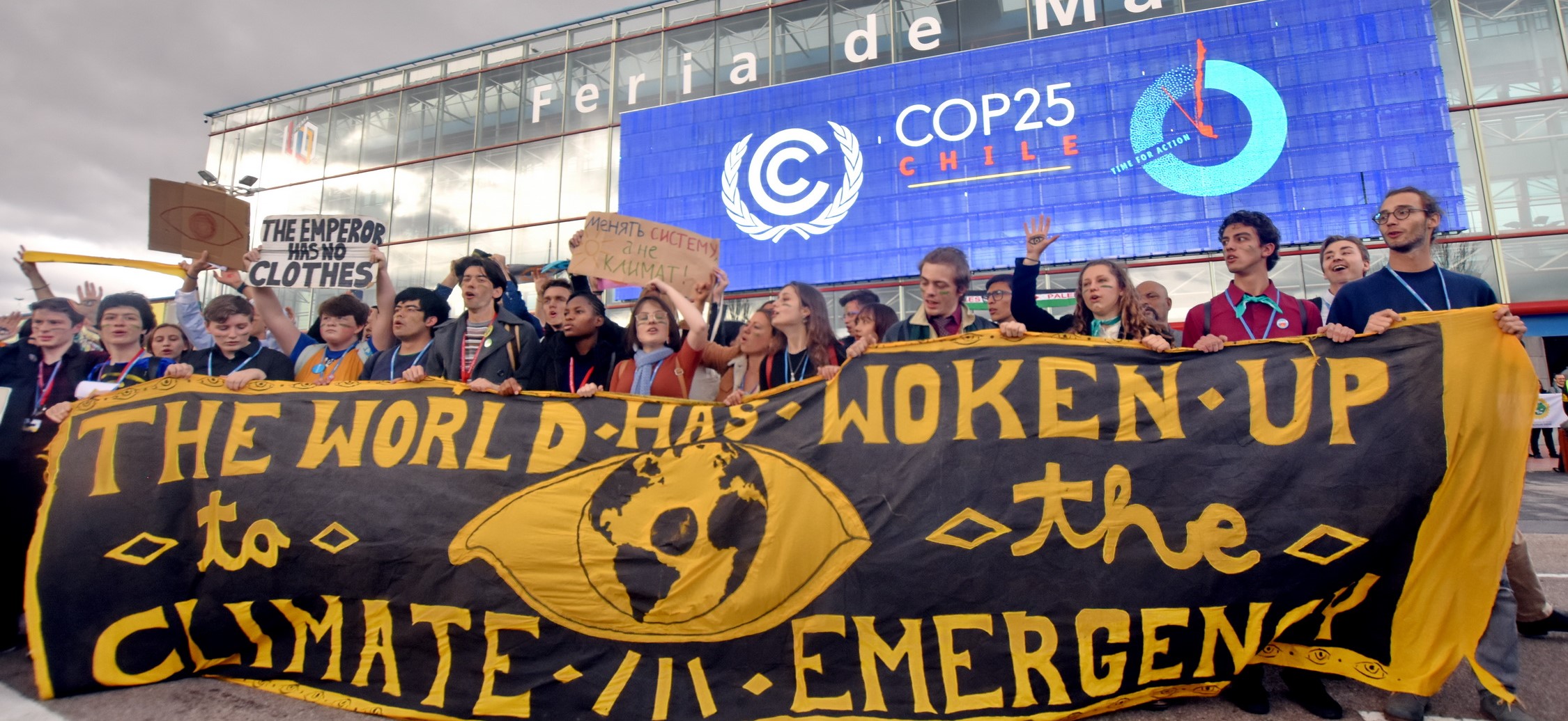 Climate protestors holding a banner that says "The world has woken up"  in front of COP25, Chile