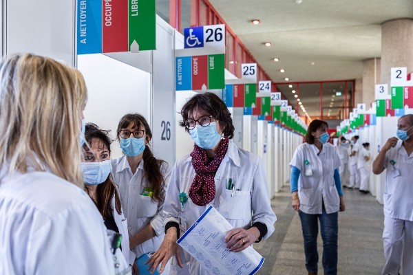 Doctor talking to other doctors at COVID-19 vaccination centre