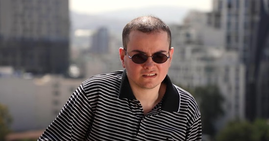 A man with visual impairment wearning black glasses and standing
