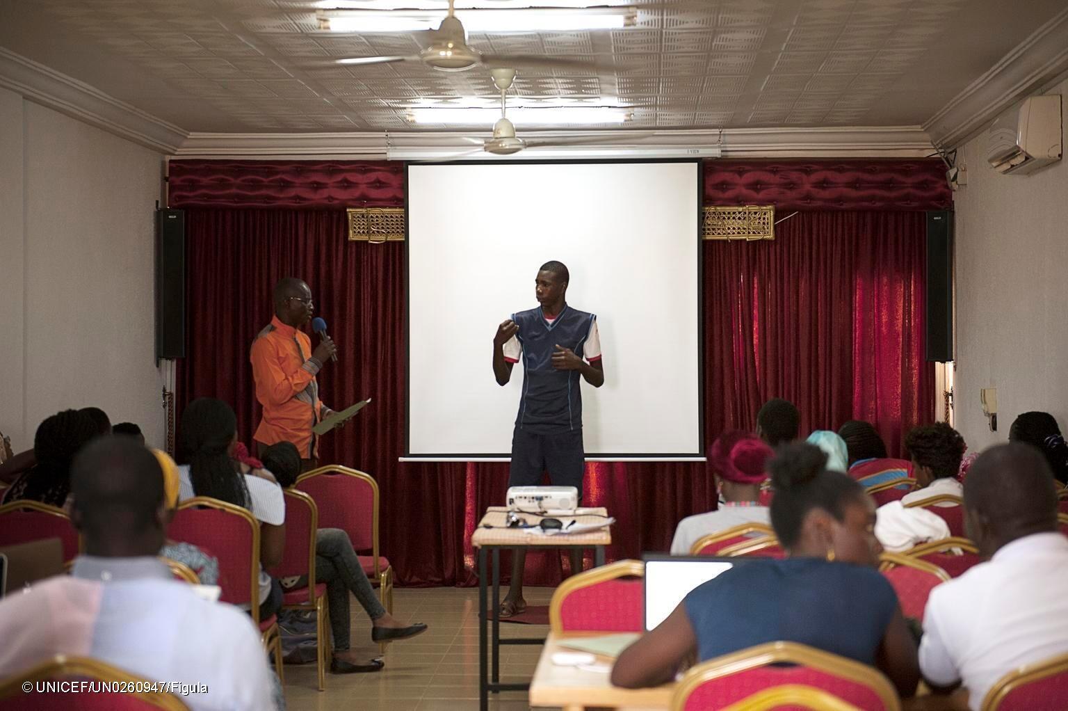 A man stands in front of a room of people