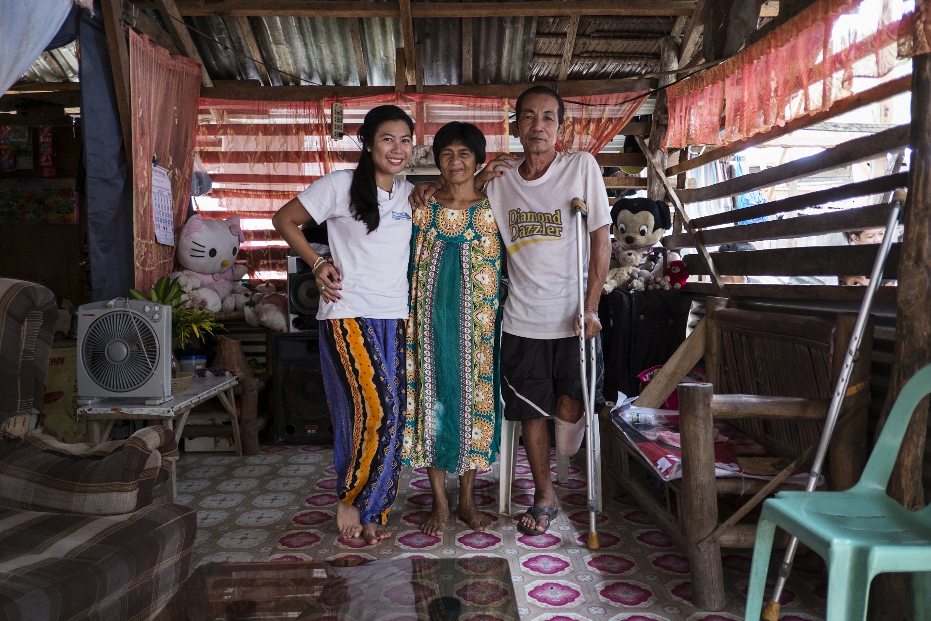 2 females and one male on crutches in a slum