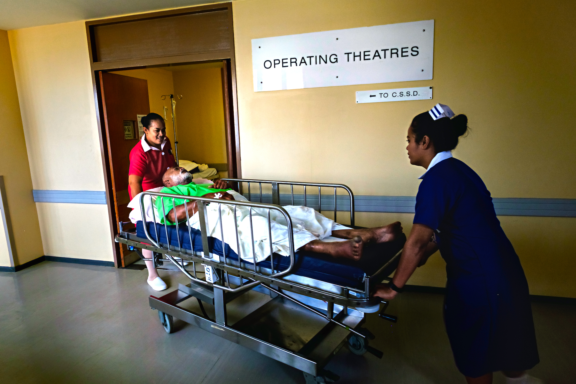 An emergency care patient being moved to operating theatre by nurses