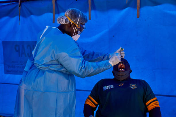 A health worker takes a saliva sample from a patient's mouth.