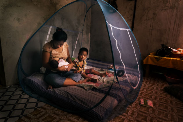 A woman and child inside a mosquito net.