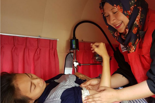 A midwife examines a child in Indonesia.
