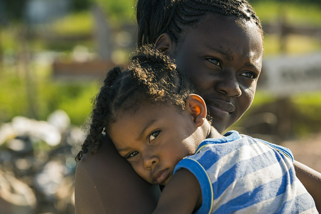 A woman holds her son in an inner-city community of Belize City, where access for women to cervical cancer screening is a challenge.
