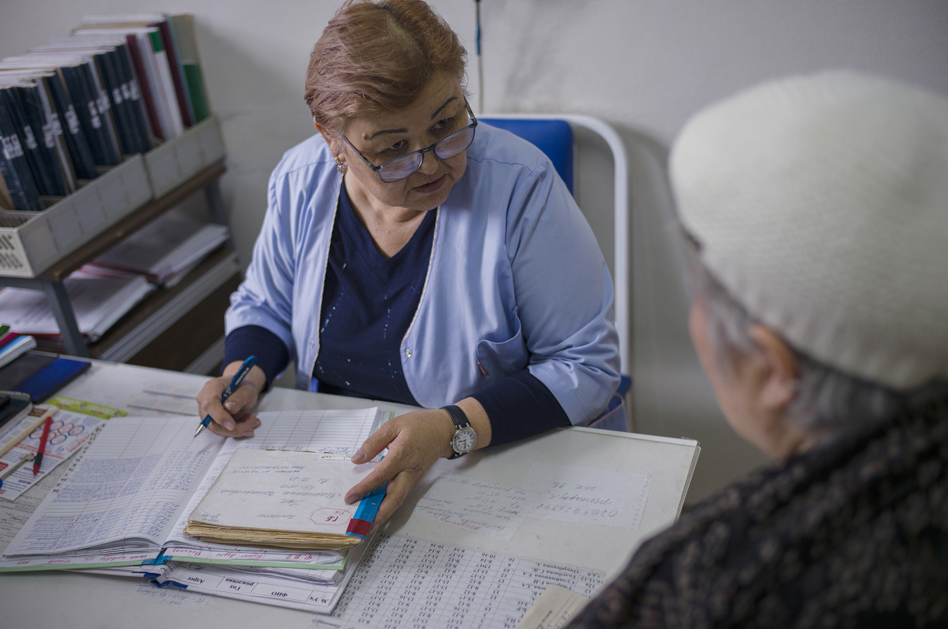 An elderly woman consults a health worker