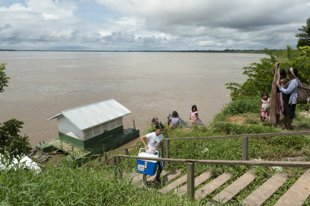 A young woman climbs up stairs from a river bank, in rural Brazil