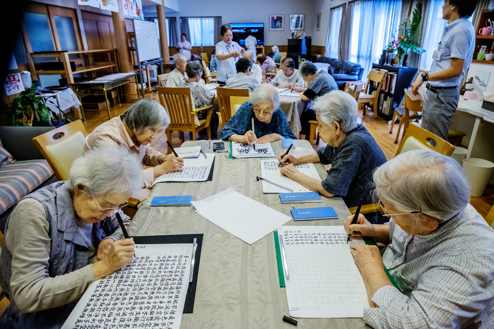 Older people doing calligraphy and Shakyo