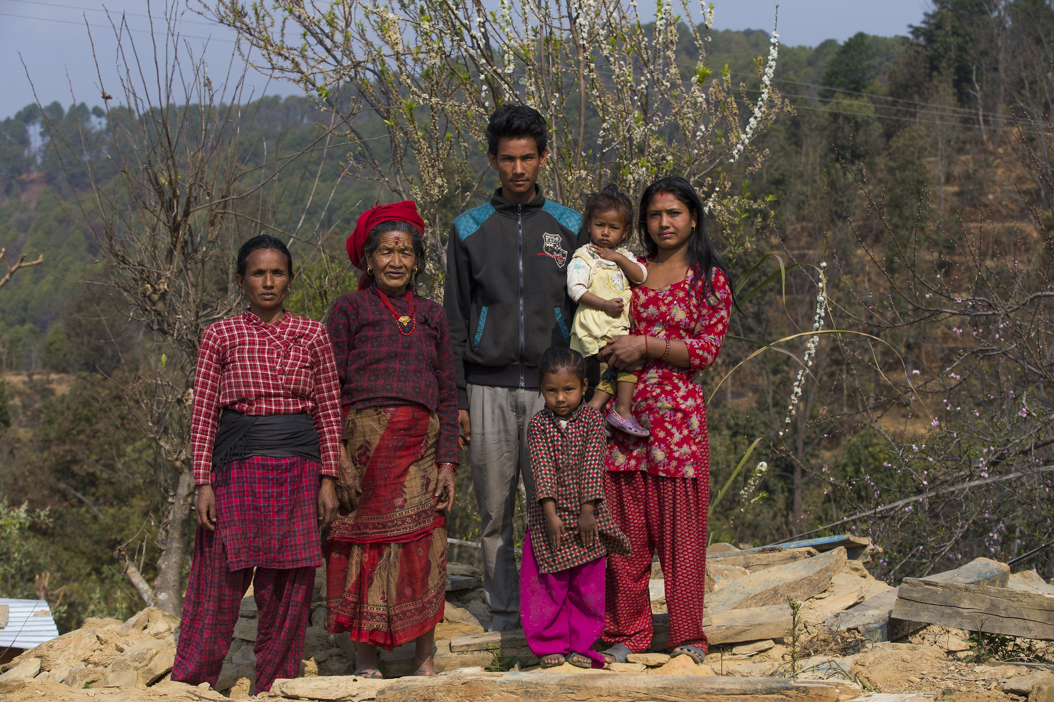 A portrait of a family from Nepal, shot in a mountainous setting.