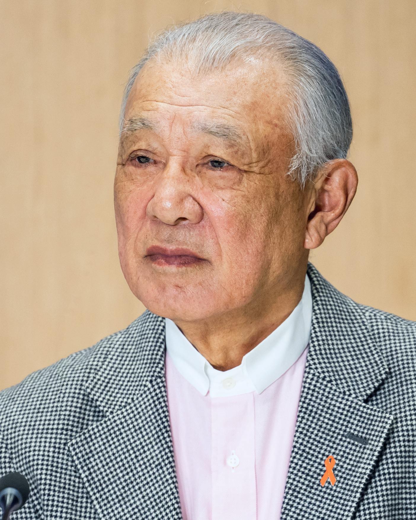Headshot of a man wearing a checked suite.
