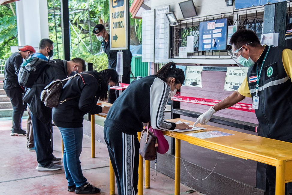 Thais returning home from Cambodia fill out immigration forms at Thailand’s Klong Luek border checkpoint on 28 May 2020. The border has been closed to almost all arrivals during the COVID-19 pandemic except Thai nationals