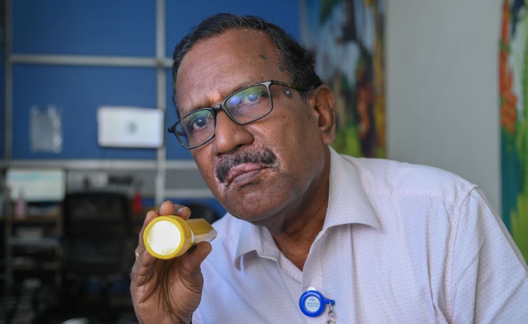 A community eye health worker with a flashlight