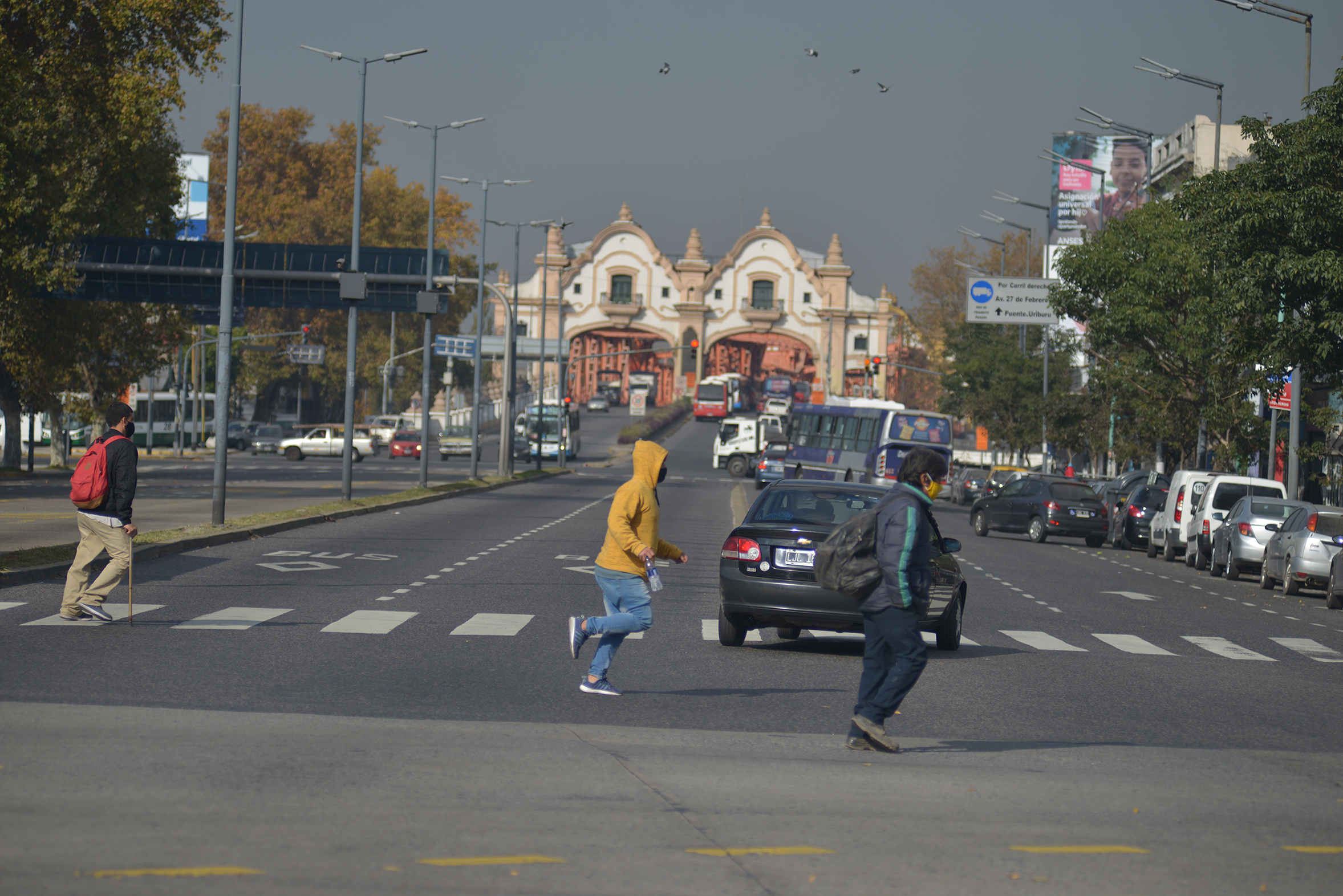 Pedestrians crossing large avenue with traffic
