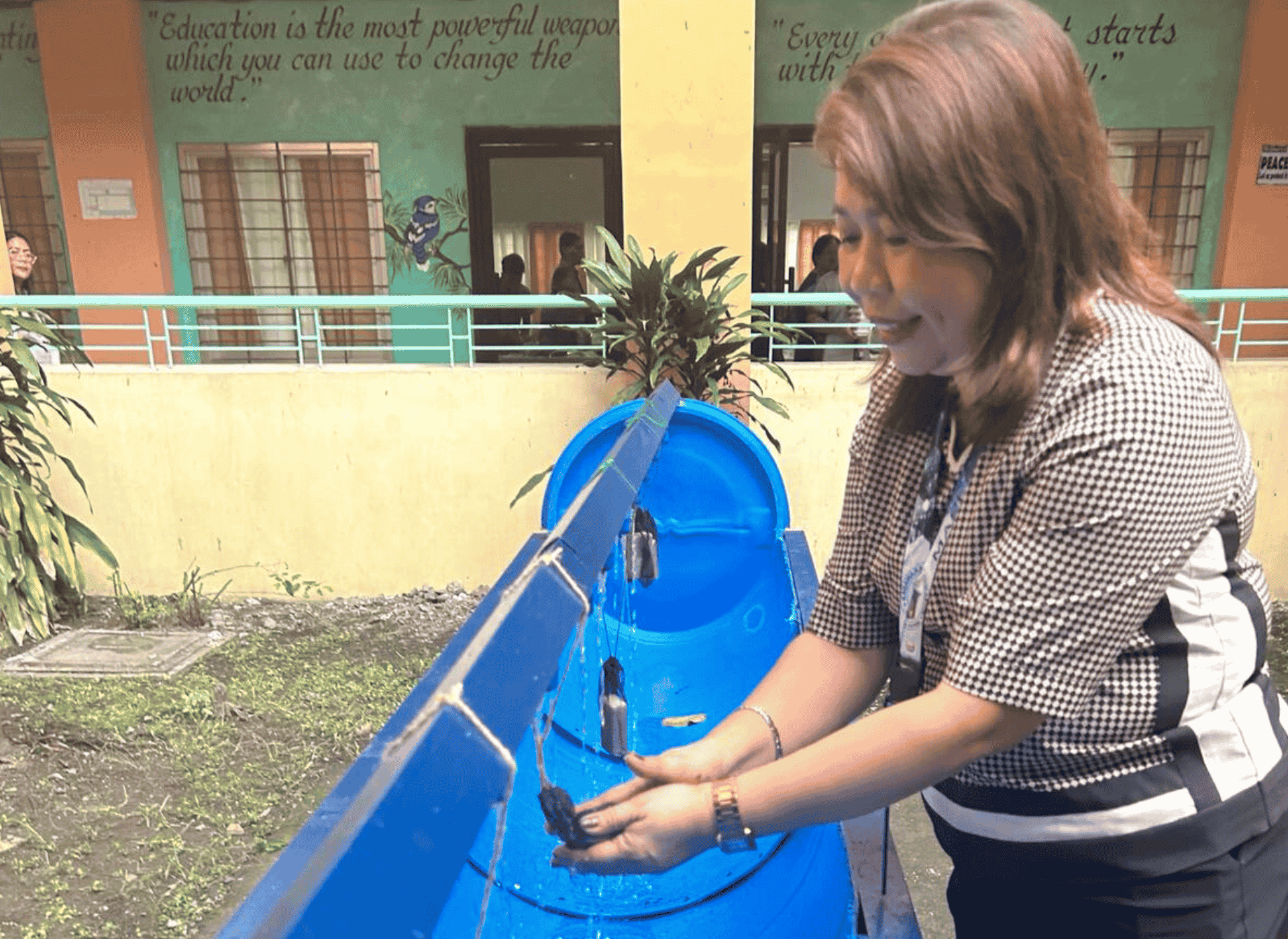 A woman washes her hands in a school handwashing facility in the Phlippines