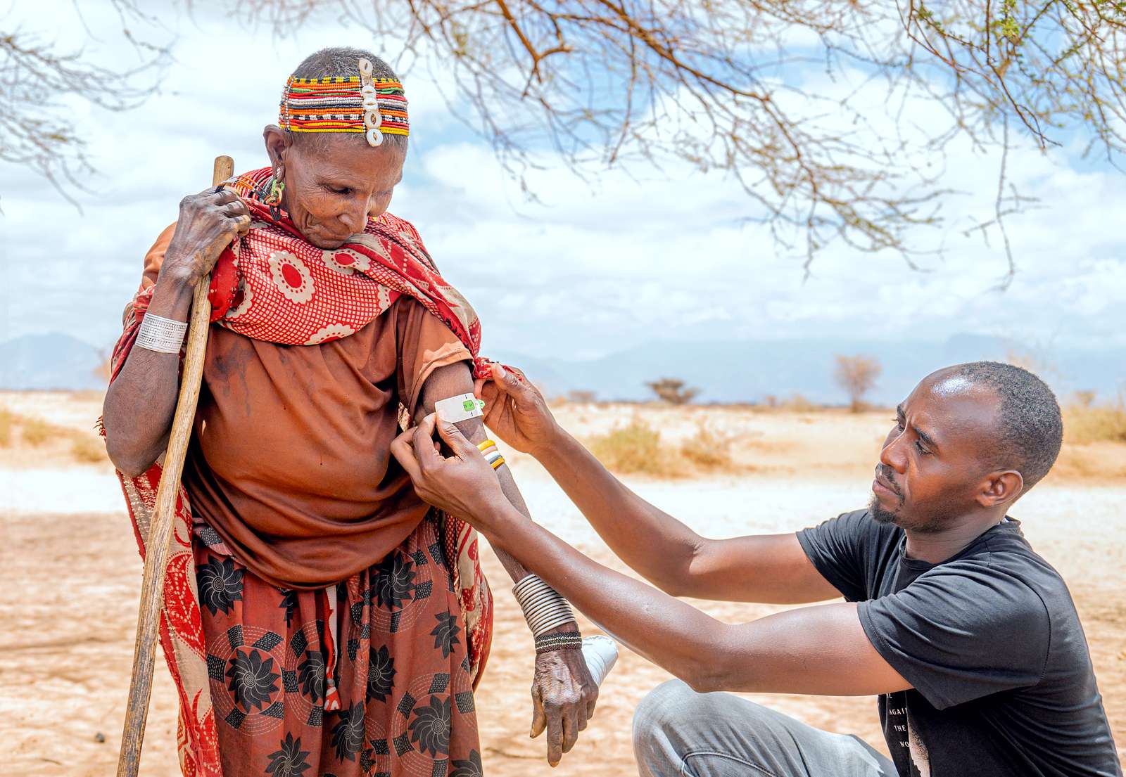 A health worker is screening a woman from a local tribe for malnutrition.